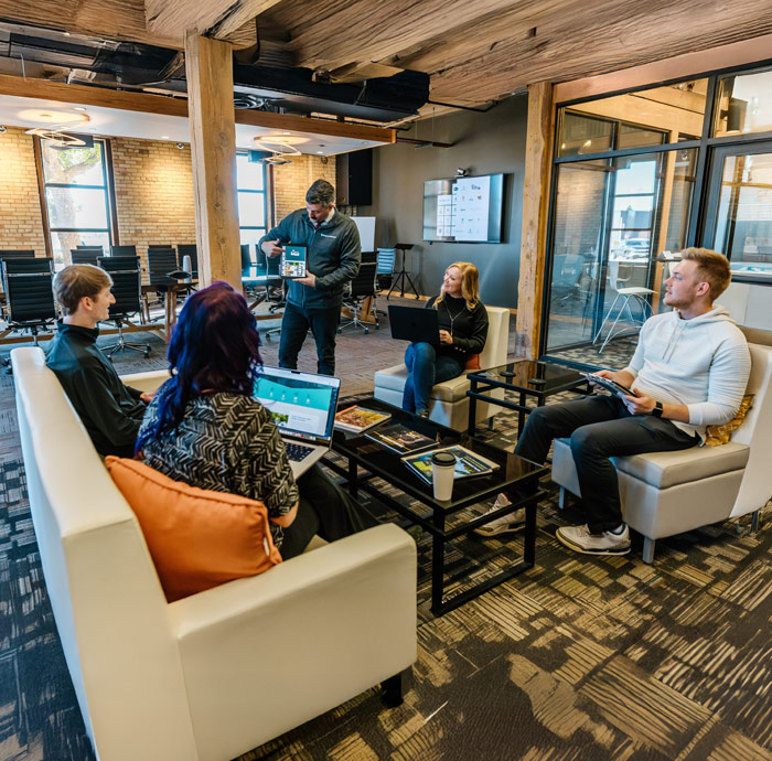 Team meeting in modern office lounge area.
